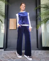 Pantalón de corte amplio y tiro medio, confeccionado en terciopelo color beige. Presenta cintura elástica con cordón ajustable y bolsillos laterales.