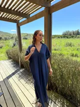 Vestido largo de lino color azul marino, con escote en V y mangas cortas amplias. Presenta un corte relajado y bolsillos laterales.