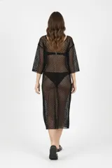 Vestido midi de red, color negro, con cuello en V profundo, mangas tres cuartos y diseño holgado.