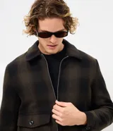 Campera de franela con estampado de cuadros, cuello tipo polo, cierre frontal con cremallera y bolsillos delanteros con solapa y botón. Cuenta con forro interior para mayor calidez.