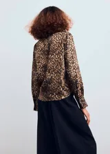 Camisa de tejido satinado con estampado de leopardo, corte recto, manga larga con puños abotonados, cuello camisero y cierre delantero con botones.