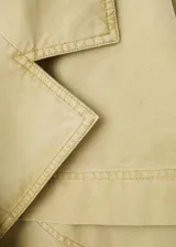 Parka oversize de algodón color verde militar, con cuello en pico, solapas con muesca, manga larga, bolsillos delanteros con solapa y cinturón ajustable del mismo tejido.