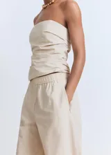 Pantalón largo color beige de tiro medio, con cintura elástica y bolsillos laterales.