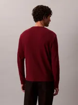 Remera de manga larga Calvin Klein en tejido térmico de punto con textura tipo nido de abeja, color bordó, de corte regular con cuello redondo y puños acanalados. Cuenta con un pequeño parche con el logo de la marca en el pecho.