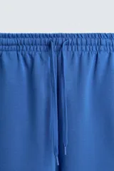 Bermuda de algodón color beige claro, corte relajado (relaxed fit), con cintura elástica ajustable mediante cordón y bolsillos laterales y trasero de plastrón.