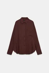 Camisa de corte oversize confeccionada en mezcla de viscosa, con diseño de rayas verticales, cuello solapa, manga larga con puños, bolsillo de plastrón en el pecho y cierre frontal con botones.
