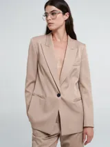 Blazer color beige con solapas y cierre con un botón.