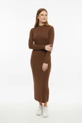 Vestido midi de punto color marrón, de corte ajustado al cuerpo, con mangas largas y cuello redondo a la base. Presenta un diseño de textura acanalada en la falda y un patrón de tejido diferente en el torso.