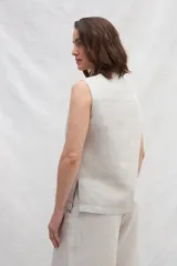 Chaleco azul de lino con cuello mao, abotonado al frente y bolsillos ojal con ribete blanco.