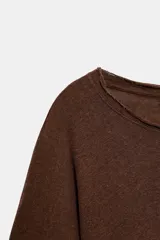 Camiseta de corte holgado confeccionada en una mezcla de algodón y lino, con cuello redondo y mangas tipo capa acampanadas.