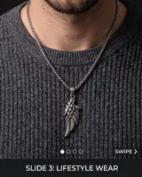 Dije de acero quirúrgico con diseño de ala y detalles de plumas en relieve.