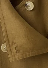 Chaqueta corta de lino color verde militar, con cuello solapa ancho, doble botonadura frontal y bolsillos laterales.
