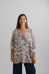 Sweter de punto con escote en V y mangas largas con puños vueltos. Presenta un diseño holgado con estampado animal print en tonos neutros.