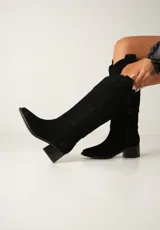 Botas texanas de cuero color beige con caña alta, taco de madera y cierre lateral.