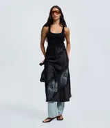 Pollera midi de satén negro con corte evasé, cintura elástica y detalle de entremedio de encaje aplicado en diagonal.