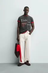 Camiseta de manga corta y cuello redondo, color negro con efecto lavado. Presenta un estampado frontal con un corazón rojo y texto en blanco que dice "Kinda Care Kinda Don't".