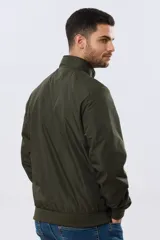 Campera liviana de nylon color azul marino, con cuello alto, cierre frontal y puños y dobladillo en elástico tejido.