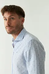 Camisa de manga larga color rosa claro con pequeños lunares azules, confeccionada en lino y algodón, de corte regular y logo bordado.