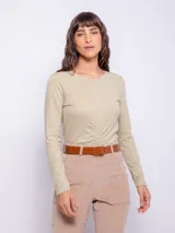 Remera blanca de manga larga con cuello redondo y frunces verticales en el centro.