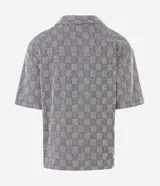 Camisa de manga corta Marfinno con corte boxy, cuello bowling y cierre frontal abotonado. Confeccionada en tejido texturizado con diseño geométrico de cuadros.