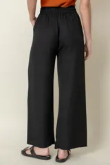 Pantalón ancho color ladrillo, de viscosa y poliéster, con cintura elastizada, cordón para ajustar y bolsillos laterales.