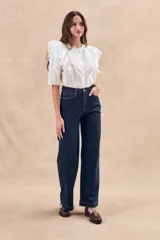 Blusa blanca de algodón con bordado floral, cuello redondo, manga corta con volados y cierre frontal con botones.