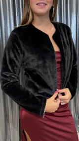 Chaqueta de textura suave tipo peluche, color negro, con diseño de corte corto y mangas largas. Presenta un estilo abierto sin cierres frontales.