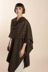 Ruana de lana fina color crudo con terminación envivada.