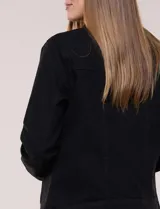 Campera de jean blanca de corte clásico, con cuello solapa, cierre frontal de botones metálicos y bolsillos aplicados con solapa en el pecho.