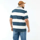Remera de estilo rugby con cuello polo, manga corta y diseño a rayas horizontales en azul y blanco. Presenta estampado frontal con texto y logo, además de botones en el cuello.