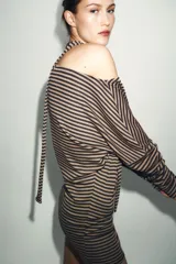 Vestido midi de punto a rayas horizontales en tonos marrón y negro, con cuello barco y mangas largas. Incluye un cinturón ajustable de la misma tela.