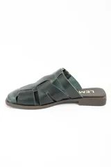 Zueco tipo cangrejera de cuero lavado color verde oscuro, con diseño de tiras entrelazadas y hebilla metálica lateral ajustable.