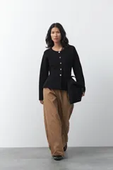 Cardigan negro de tejido de punto con cuello redondo y cierre frontal con botones a contraste. Presenta un corte entallado en la cintura con una silueta levemente evasé y mangas largas.