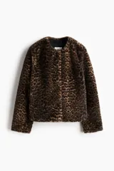 Campera de piel sintética con estampado de leopardo, cuello redondo y cierre frontal con botones. Presenta un diseño de corte recto y forro interior.