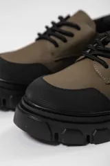 Zapato acordonado de cuero negro con suela track.