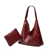 Bolso tipo hobo de cuero sintético color bordó, con correa de hombro y cierre superior. Incluye minibag de regalo.