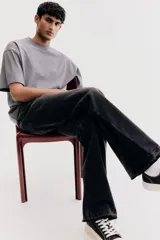 Remera gris de algodón de peso medio, corte oversized, con cuello redondo ribeteado, hombros caídos y bajo recto.