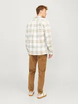 Sobrecamisa a cuadros color crema, marrón y blanco, de manga larga con cierre de botones y bolsillos en el pecho.