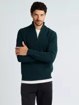Sweater de punto color verde oscuro, con cuello alto y cierre frontal parcial, de manga larga y puños acanalados.