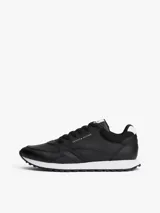 Zapatillas deportivas Tommy Hilfiger de estilo running, confeccionadas en una mezcla de piel y poliuretano. Presentan un diseño de corte bajo con cordones, paneles de texturas mixtas, detalles de ventilación en la parte superior y suela de goma con tacos.