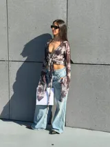 Top de gasa translúcida con estampado batik en tonos negros y blancos, de manga larga amplia y diseño cruzado para atar al frente.