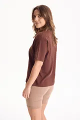 Remera de algodón amarilla de manga corta, con corte suelto y pequeño aplique rectangular en el pecho.