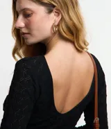 Blusa de manga larga, color blanco, con cuello redondo y textura de punto calado con diseño geométrico.