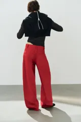 Jeans estilo baggy oversize de tiro medio en color rojo, con cinco bolsillos, trabillas para cinto y costuras decorativas marcadas en las piernas.
