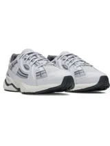 Championes Under Armour modelo Sola, de diseño retro con líneas esculpidas. Presentan una parte superior de malla y material sintético en tonos grises, con soporte de arco de TPU y entresuela de EVA acolchada para mayor comodidad.