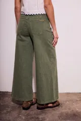 Pantalón tipo wide leg de tiro medio, confeccionado en denim de algodón con acabado lavado en tono verde oliva. Presenta diseño de cinco bolsillos, cierre frontal con botón y cremallera, y corte recto de pierna ancha.