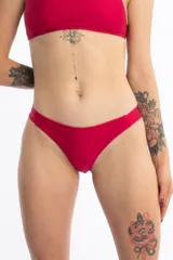 Bombacha de bikini tipo vedetina color rojo, confeccionada en tela con acabado brillante. Presenta un diseño sin elásticos en los laterales para mayor comodidad.