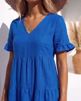 Vestido corto color azul de lino, con escote en V, mangas cortas con volados y diseño escalonado en la falda.