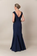 Vestido largo de fiesta azul marino, corte sirena, con escote en V y apliques de piedras bordadas en el escote.