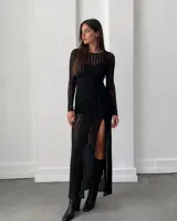 Vestido largo de microtul elastizado negro con diseño de líneas verticales translúcidas, calce al cuerpo, manga larga y tajo lateral en la pierna.